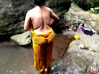 Ashok and Surwana Kumari take turns pissing in public while bathing in a tarn in the woods